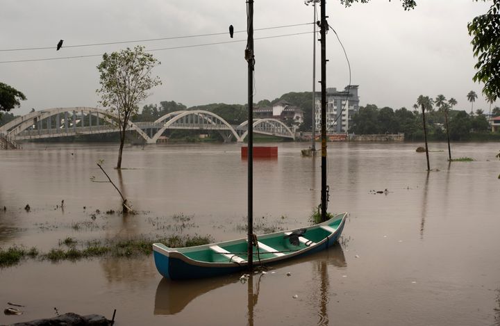 A boat is seen anchored to a pole after the Periyar river overflowed following heavy monsoon rains in Kochi, Aug. 8, 2020. 