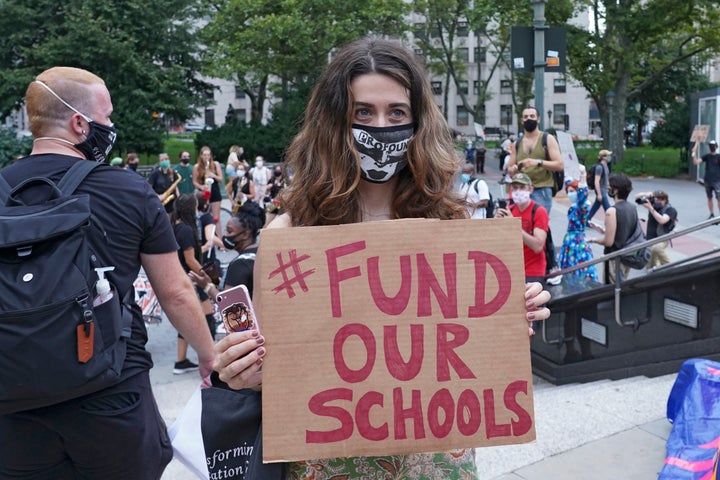 A protester holds a placard that says Fund Our Schools during a demonstration in New York City earlier this month. Several groups, including the United Federation of Teachers, gathered on the National Day of Resistance to protest against reopening of schools as well as for removing police from schools.