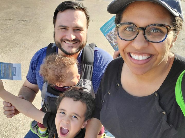 Candace Valenzuela with her husband, Andy, and two children knock on doors as she campaigns for the U.S. House in February.