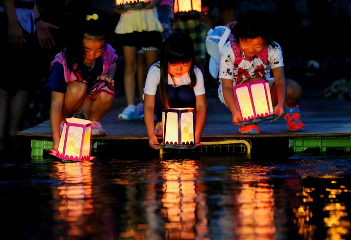 日航機墜落事故から30年となるのを前に、犠牲者の冥福を祈り、墜落現場近くの川に灯籠を流す子どもたち（2015年8月11日夜、群馬県上野村）