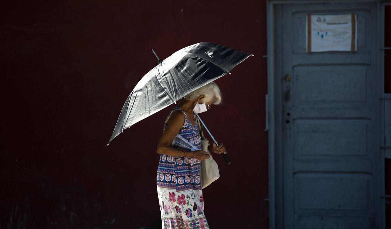 Με μάσκα και ομπρέλα στη Αβάνα της Κούβας. 