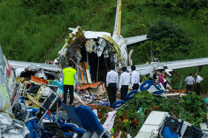 Officials inspect the wreckage of an Air India Express jet at Calicut International Airport in Karipur, Kerala, on August 8, 2020.