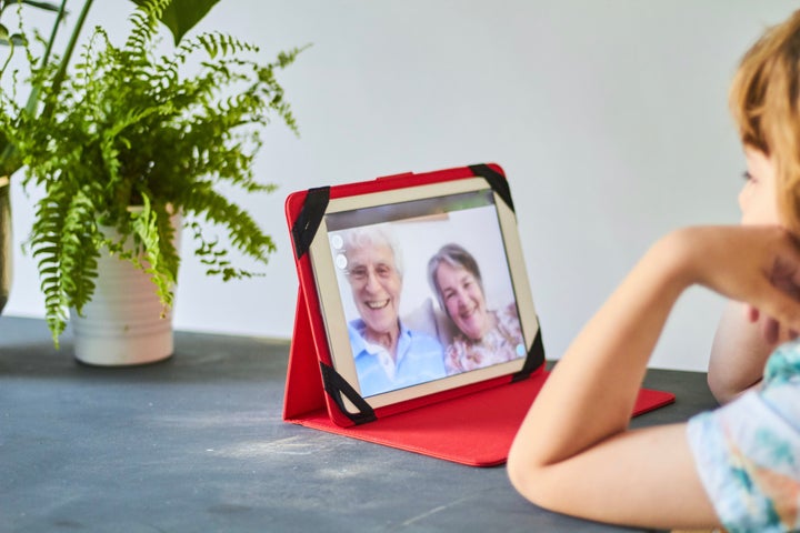 Boy talking with his grandparents using a portable digital device