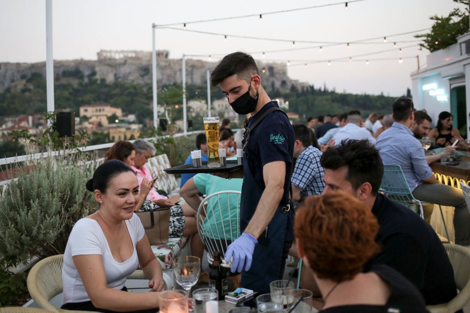 Garçom atende clientes em bar de Atenas, Grécia, em 1º de agosto. Desde que o país...