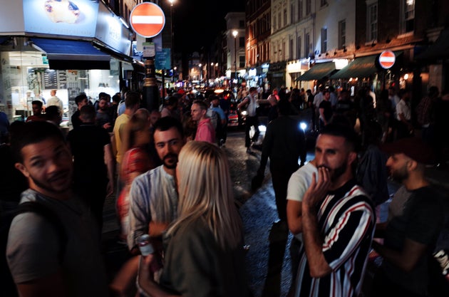 Revelers socialize on Old Compton Street in the hospitality and nightlife hotspot of Soho in London on...