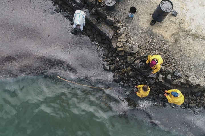 People scoop leaked oil from the MV Wakashio bulk carrier. 