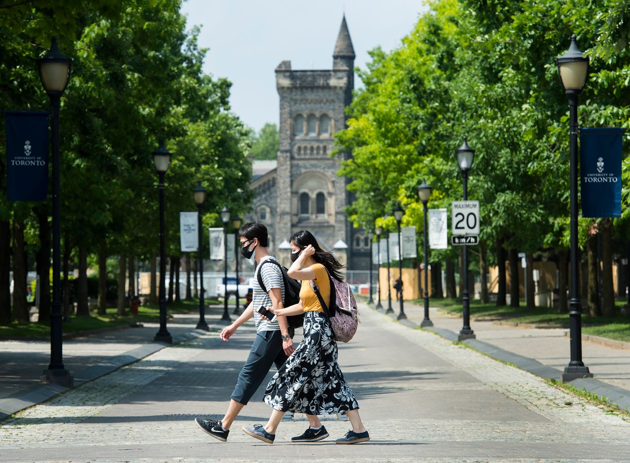 People walk past the University of Toronto campus during the COVID-19 pandemic in Toronto on Wednesday, June 10, 2020. 