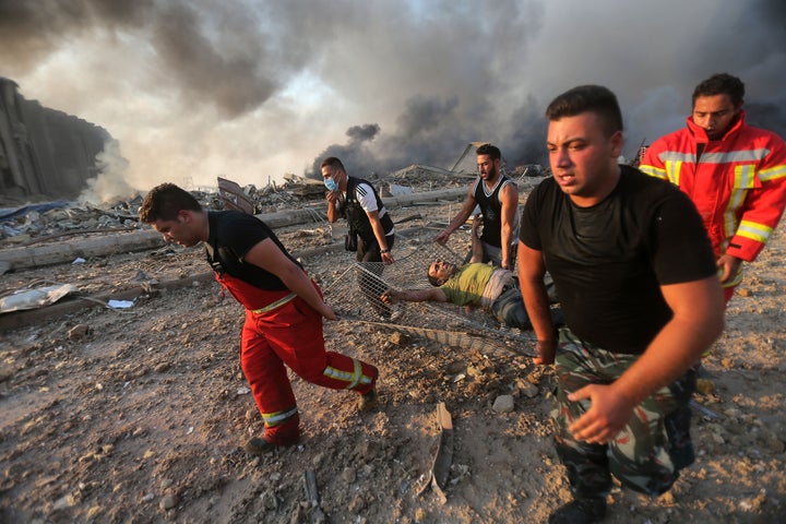 Firefighters evacuate a wounded man from the scene of an explosion at the Port of Beirut on Aug. 4, 2020.