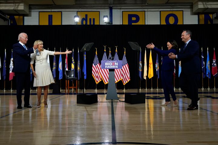 Sen. Kamala Harris (D-Calif.) and her husband, Douglas Emhoff, right, applaud to Democratic presidential candidate Joe Biden and his wife, Jill Biden, after a campaign event at Alexis Dupont High School in Wilmington, Delaware on Aug. 12.