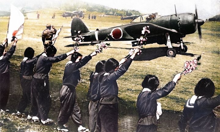 1945年4月12日、知覧飛行場にて。特攻に向かう穴澤利夫少尉の「隼」を見送る知覧高等女学校の生徒たち。