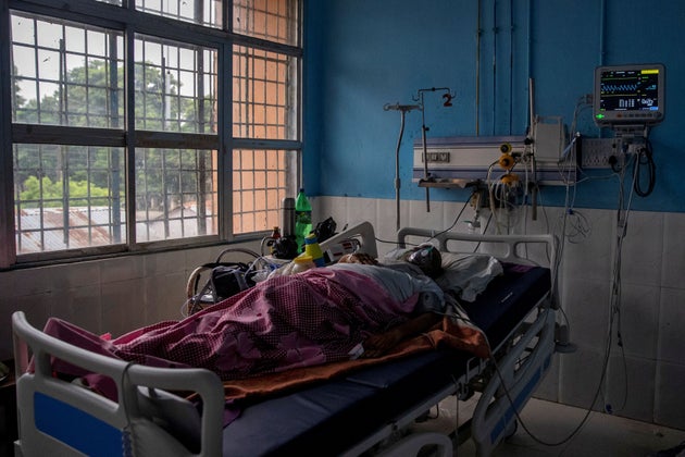A COVID-19 patient lies on a hospital bed in the Intensive Care Unit of Jawahar Lal Nehru Medical College...