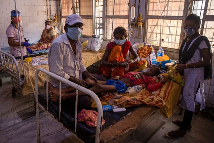 A patient suffering from diabetes lies on a hospital bed as his family look after him on the emergency ward of Jawahar Lal Nehru Medical College and Hospital,in Bhagalpur, Bihar, India, July 26, 2020. 