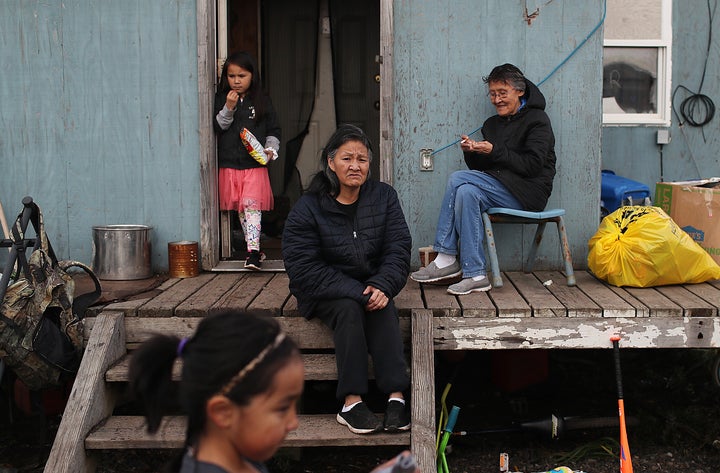 Lizzy Hawley (C) and her sister Ella Hawley (R) relax together on September 10, 2019 in Kivalina, Alaska.