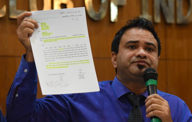 Dr. Kafeel Khan shows a document absolving him of medical negligence and corruption during a press...