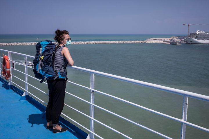 ANCONA, ITALY - AUGUST 7: A woman looks at her arrival from the deck of a passenger ship arriving from Greece to port on August 7, 2020 in Ancona, Italy. Passenger ships resume sailings more than three months after they were suspended due to coronavirus travel restrictions. (Photo by Siegfried Modola/Getty Images)