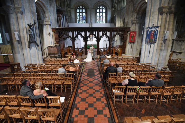 Tina-Lynn Birch and Billy Bryant get married inside the Priory Church of St Peter, as weddings were permitted to take place in the country with ceremonies capped at a maximum of 30 guests, in Dunstable, England, Saturday July 4.