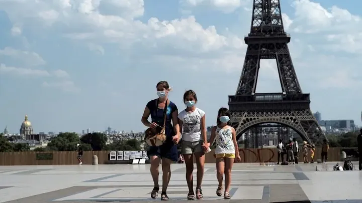 Personas paseando con mascarilla por París.
