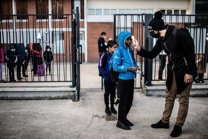 Students have their temperatures checked before entering the Saint-Exupery school in the Paris' suburb of La Courneuve on May 14.