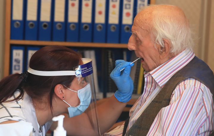 Assistant manager Claire Welford administers a coronavirus swab test on resident Harry Hall, 94, at the Eothen Homes care home in Whitley Bay, Tyneside