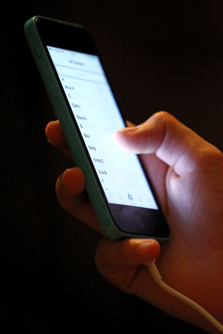 Stock picture of a teenage girl using an iPhone.