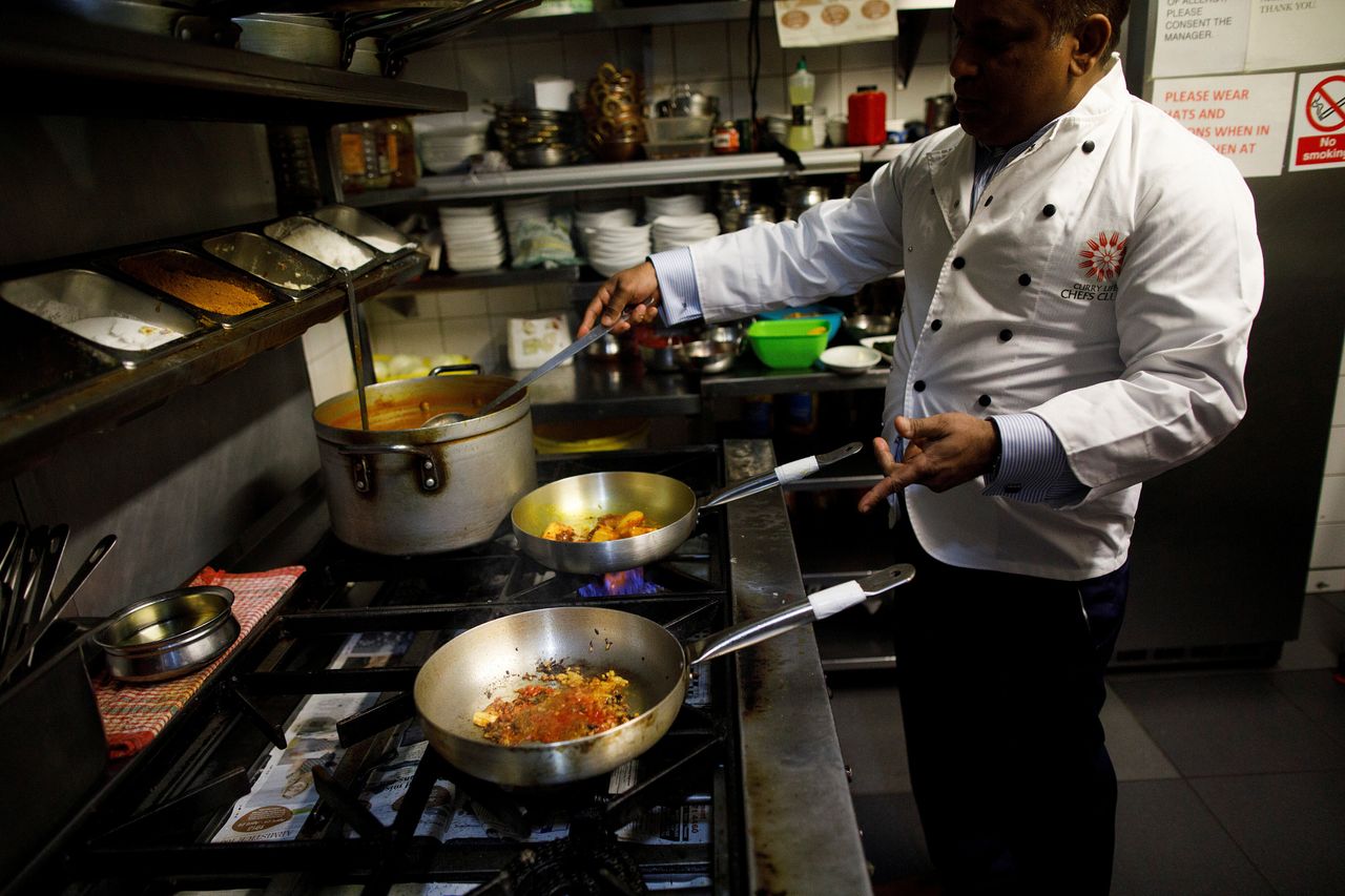 Abdul Ahad, owner of the City Spice curry house, cooks a meal in the kitchen of his restaurant in Brick Lane.