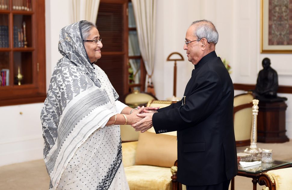 President Pranab Mukherjee (R) greets Bangladeshi Prime Minister Sheikh Hasina (L) moments after the Bangladeshi head of state arrived in New Delhi to attend the funeral services for Mukherjee's wife on August 19, 2015.