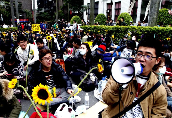 台湾の立法院（国会）議場前で、運動のシンボル、ヒマワリを手に座り込む学生たち（2014年3月22日/台湾・台北）