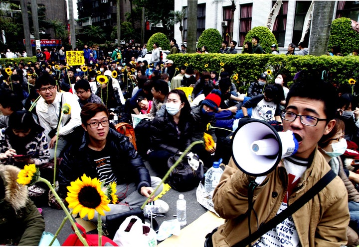 台湾の立法院（国会）議場前で、運動のシンボル、ヒマワリを手に座り込む学生たち（2014年3月22日/台湾・台北）