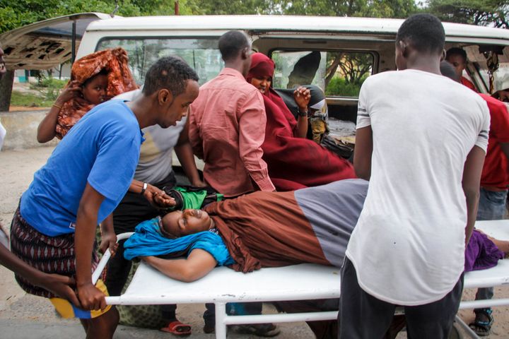 Trabajadores médicos y otros somalíes ayudan a una mujer que resultó herida cuando un coche bomba explotó frente al Hotel Elite, el domingo 16 de agosto de 2020, en Mogadiscio, Somalia. (AP Foto/Farah Abdi Warsameh)