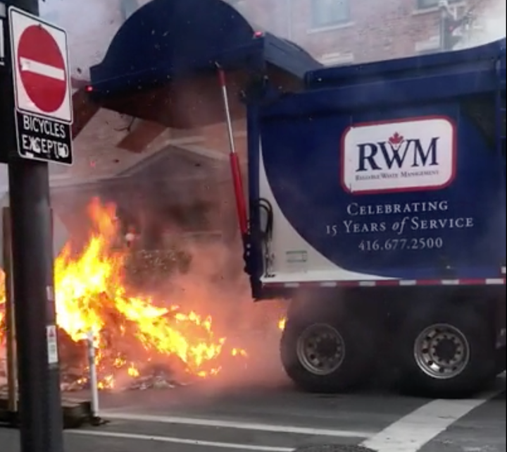 A garbage truck releases its firey load in downtown Toronto on Aug. 17, 2020.