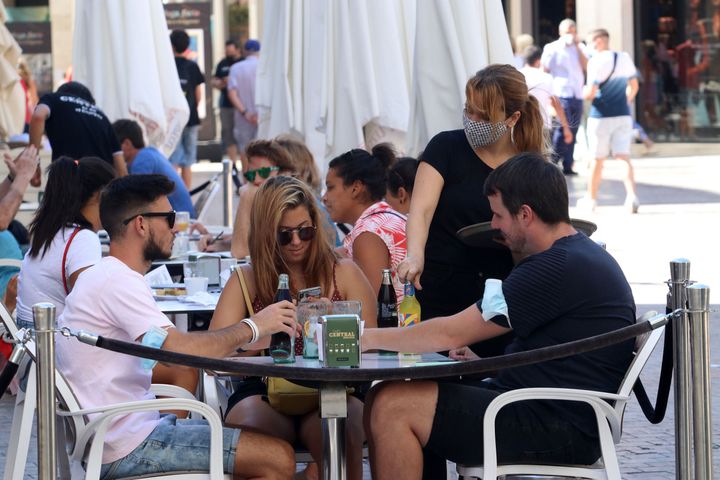 Una camarera atiende en una terraza de un bar en Málaga. 