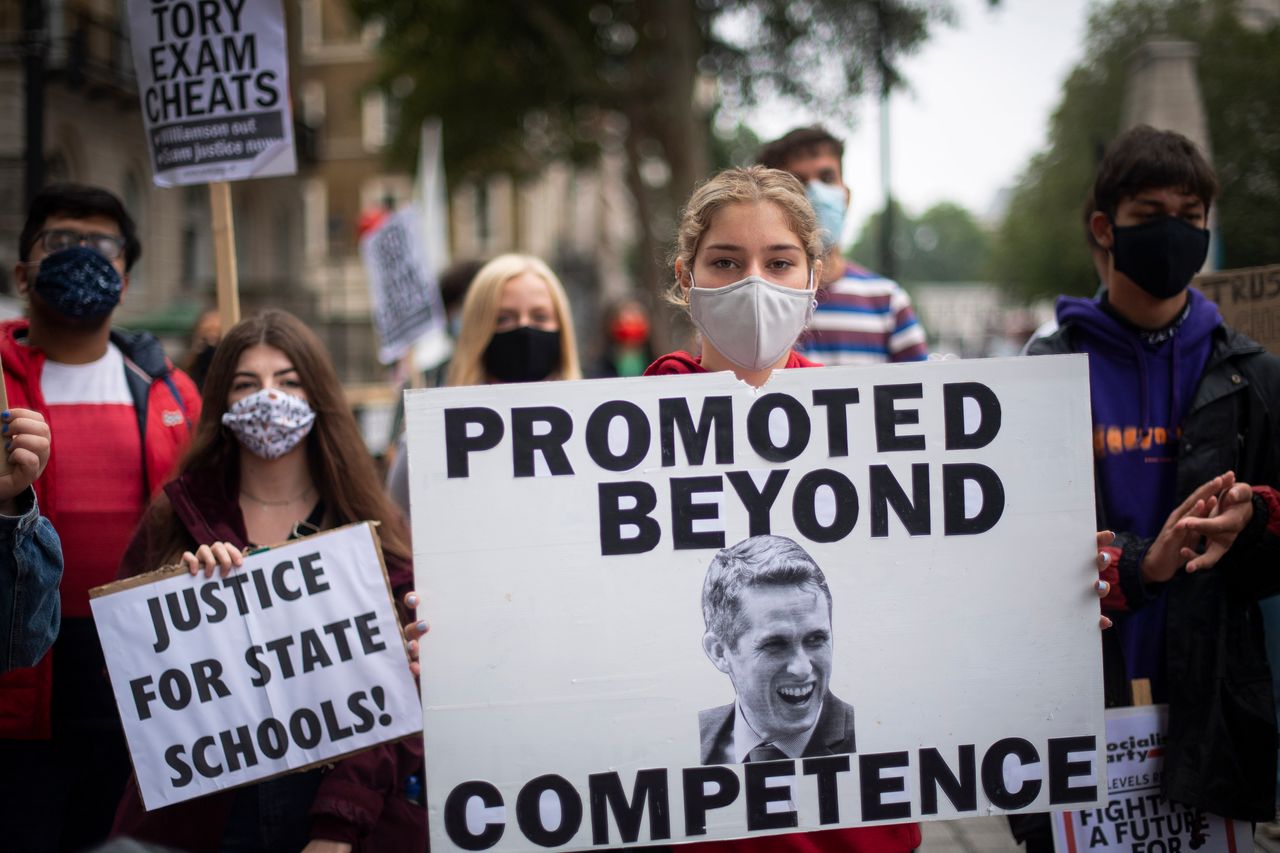 Students wearing face masks take part in a protest in Westminster in London over the government's handling of A-level results, university provision and bleak employment prospects.