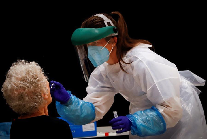 Una sanitaria realiza un test de coronavirus a una paciente.