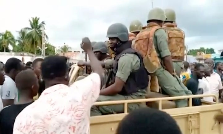 Soldiers are greeted by crowds of people, as military are stationed around President Ibrahim Boubacar Keita's city residence