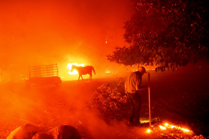 Bill Nichols, 84, tries to protect his home as fire consumes Vacaville on Wednesday.