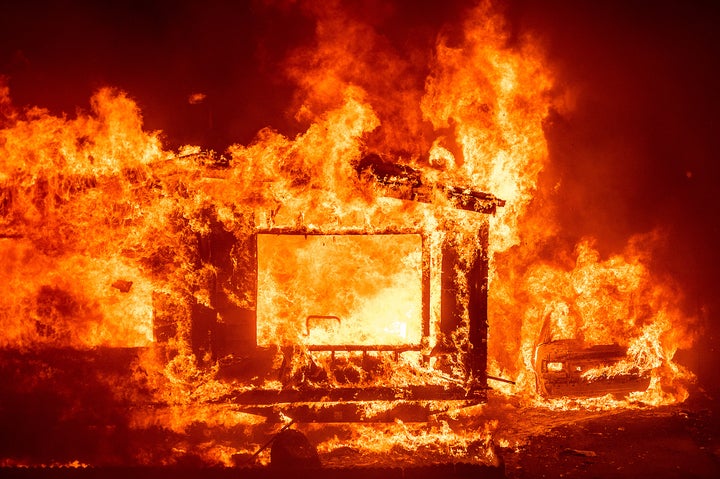 A mobile home and car burn at Spanish Flat Mobile Villa as the LNU Lightning Complex fires tear through unincorporated Napa County, Calif., on Tuesday, Aug. 18, 2020. (AP Photo/Noah Berger)