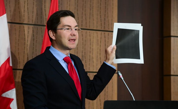Conservative MP Pierre Poilievre holds up redacted documents during a press conference in Ottawa on Aug. 19, 2020. The documents were tabled by the government at the House of Commons Finance Committee.