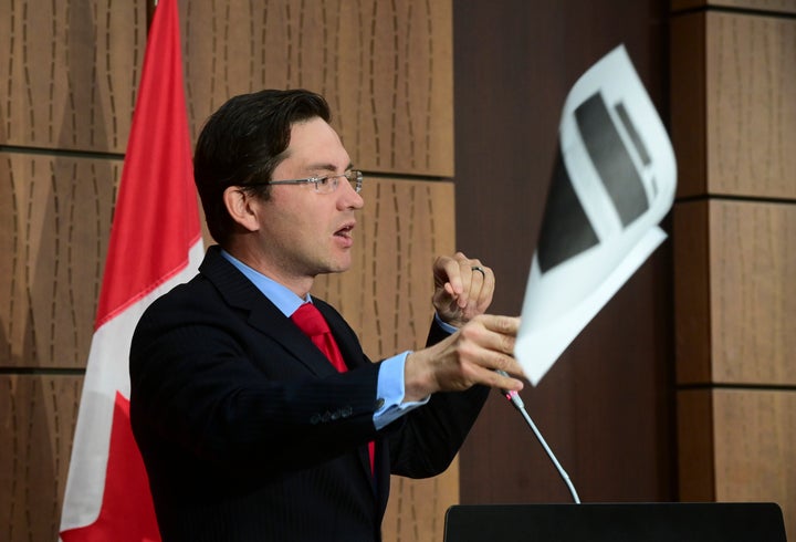 Conservative MP Pierre Poilievre throws a redacted document during a press conference on Parliament Hill in Ottawa on Aug. 19, 2020.
