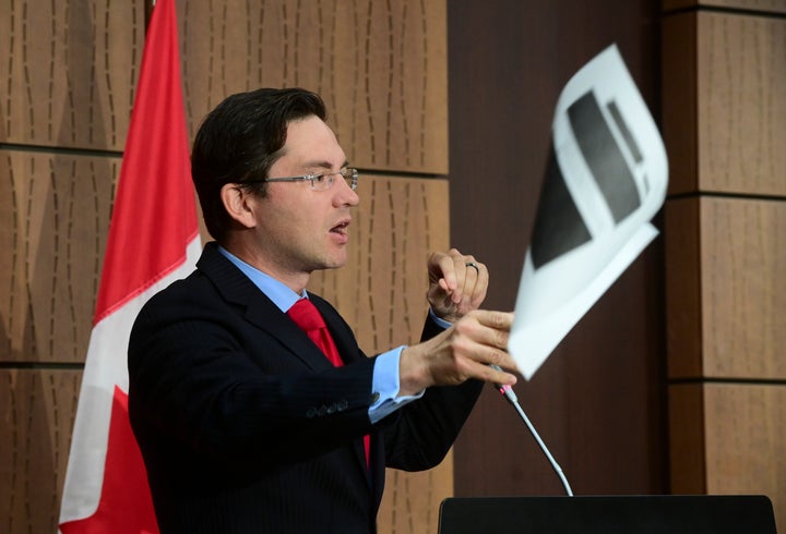 Conservative MP Pierre Poilievre throws a redacted document during a press conference on Parliament Hill in Ottawa on Aug. 19, 2020. 