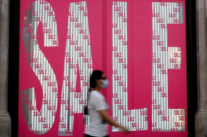 A pedestrian passes a sale sign in a shop window on Oxford Street in London, Thursday, Aug. 13, 2020. The British economy is on course to record the deepest coronavirus-related slump among the world's seven leading industrial economies after official figures showed it shrinking by a 20.4% in the second quarter of 2020 alone said The Office for National Statistics. (AP Photo/Kirsty Wigglesworth)