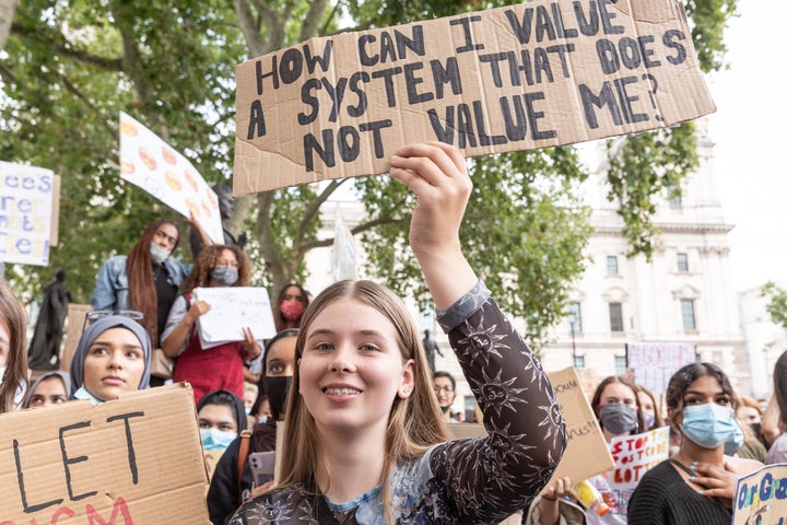 "¿Cómo puedo valorar un sistema que no me valora a mí?", se lee en la pancarta que porta una joven manifestante durante las movilizaciones estudiantiles contra los nuevos baremos de notas puestos en marcha por el Gobierno británico.