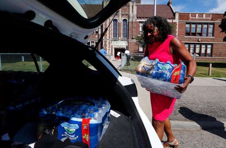 Ivy Bailey, Detroit Federation of Teachers president helps carry bottled water at Noble School in Detroit, Tuesday, Sept. 4, 2018. 