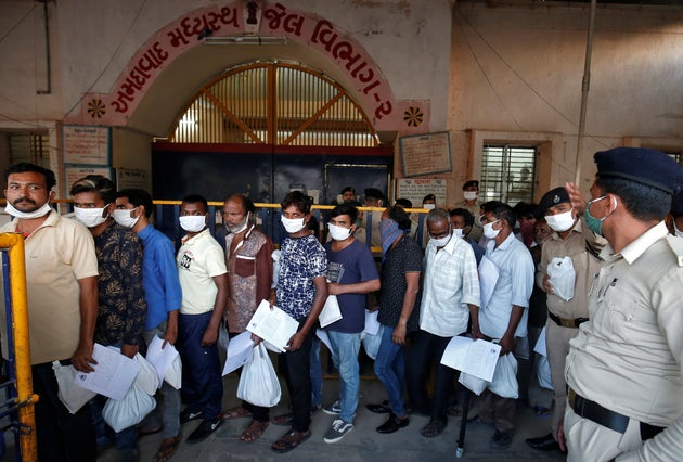 Prisoners stand in a queue after they were released on parole at the Sabarmati Central Jail in Ahmedabad,...