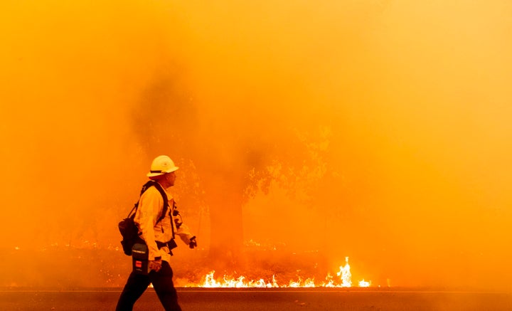 A firefighter walks down a road as flames approach in Fairfield, California, on Wednesday.