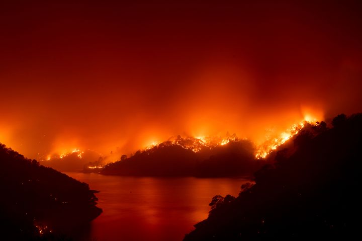 Flames from the wildfire designated as the LNU Lightning Complex are seen around Lake Berryessa in Napa County, California on Wednesday. Fire crews across the region have scrambled to contain dozens of wildfires sparked by lightning strikes.