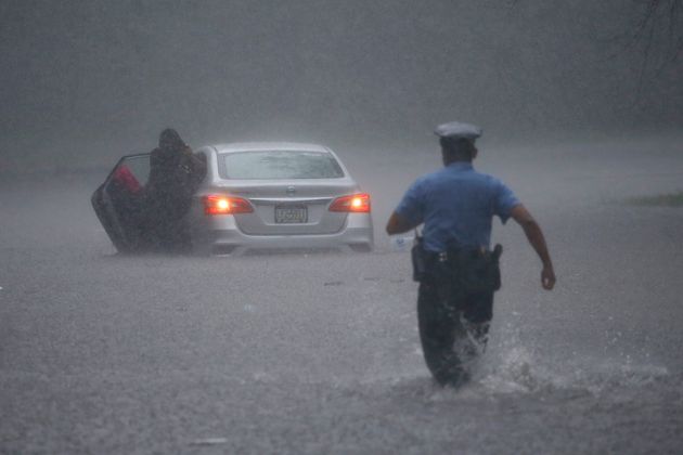 A Philadelphia police officer rushes to help a stranded motorist during Tropical Storm Isaias on Aug....