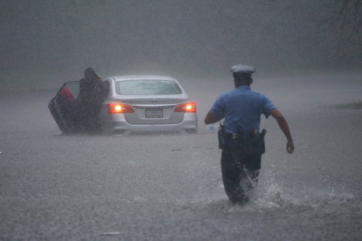 A Philadelphia police officer rushes to help a stranded motorist during Tropical Storm Isaias on Aug. 4. The storm spawned tornadoes and dumped rain during an inland march up the East Coast after making landfall as a hurricane along the North Carolina coast. It was NOAA's ninth-named storm so far this year, an unusually high number. 