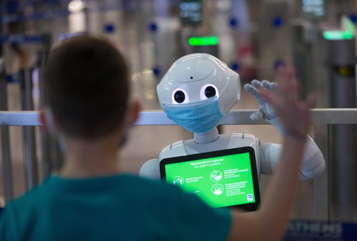 ATHENS, JUNE 26, 2020 -- A boy waves at a robot wearing a face mask and offering anti-COVID-19 information at Athens International Airport in Athens, Greece, June 26, 2020. TO GO WITH XINHUA HEADLINES OF JULY 4, 2020 (Photo by Marios Lolos/Xinhua via Getty) (Xinhua/Marios Lolos via Getty Images)