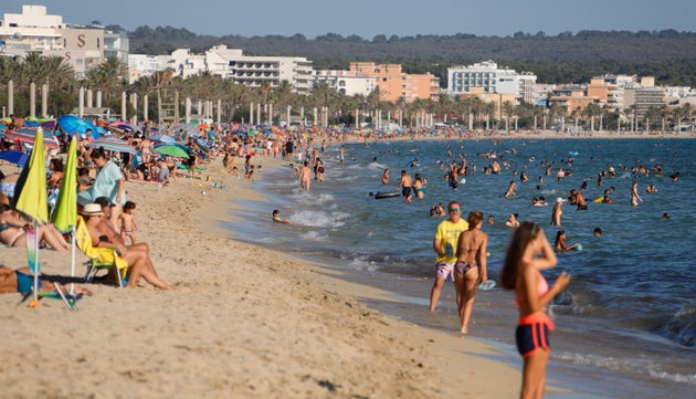 People enjoy the beach in Palma de Mallorca, Spain, on July