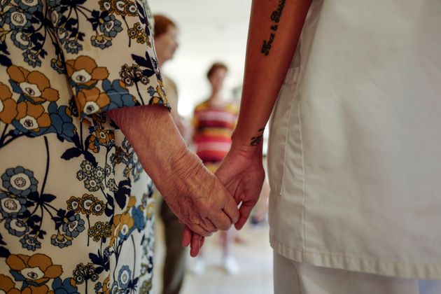 Une art-thérapeute tient la main d'une femme âgée, dans un Ehpad de Nice, le 4 août